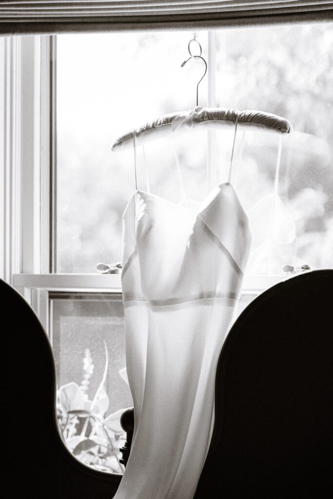 Black and white image of bride's wedding gown in Nantucket hotel window.