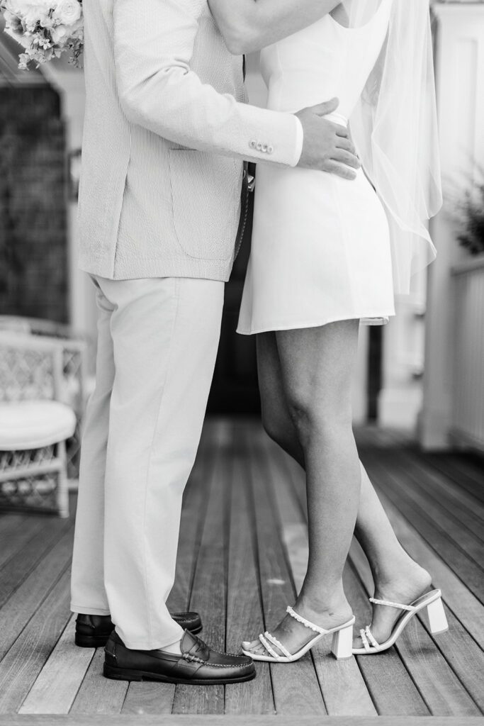 A man and woman are standing facing one another - his hands are on her waist holding her close. 