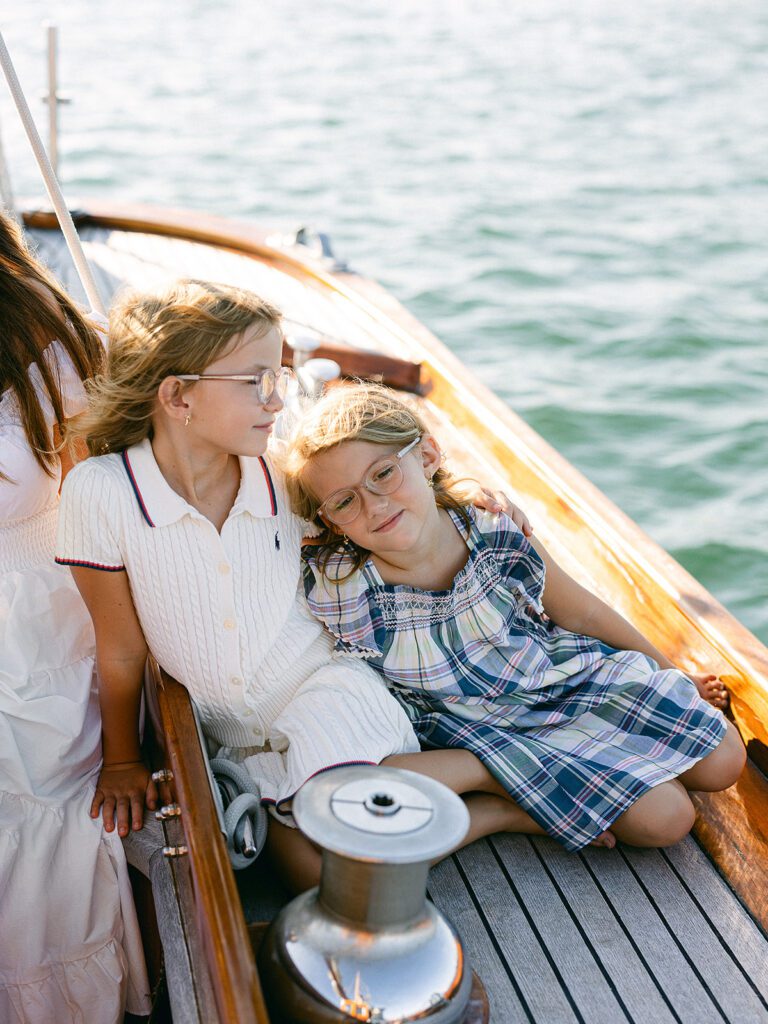 Two sisters are sitting together soaking up the view on the deck of The Blue Peter Yacht sailboat on Nantucket.