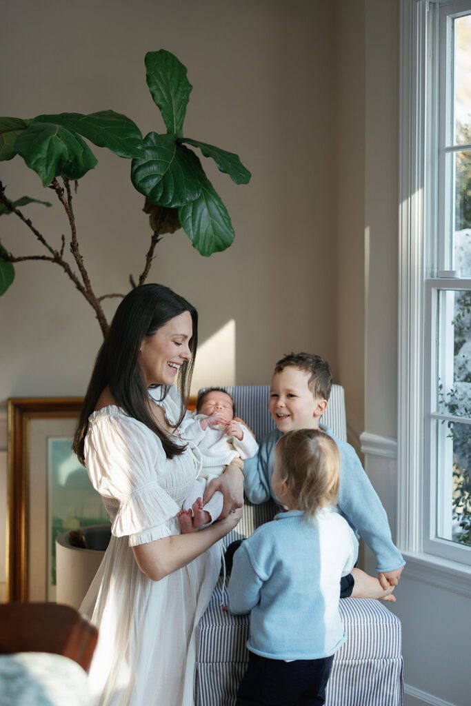 A mother introduces her two sons to their newborn baby sister in the Connecticut suburbs. 
